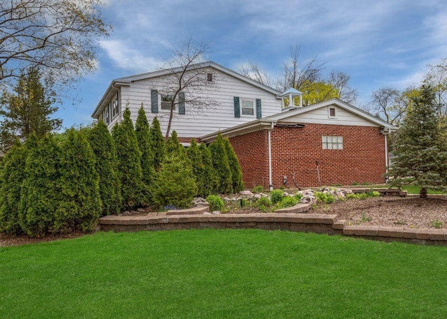 view of side of property with a yard and brick siding