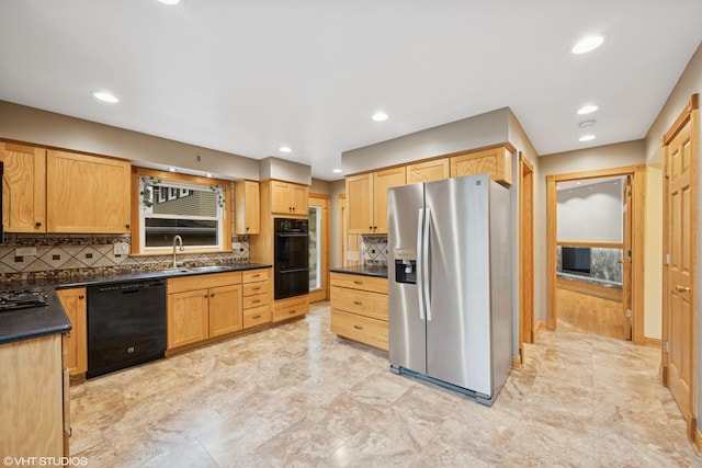 kitchen with black appliances, dark countertops, a sink, tasteful backsplash, and light brown cabinets