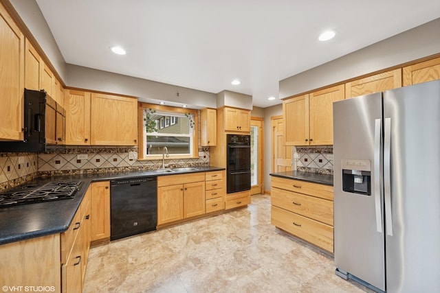 kitchen featuring black appliances, a sink, dark countertops, light brown cabinets, and backsplash