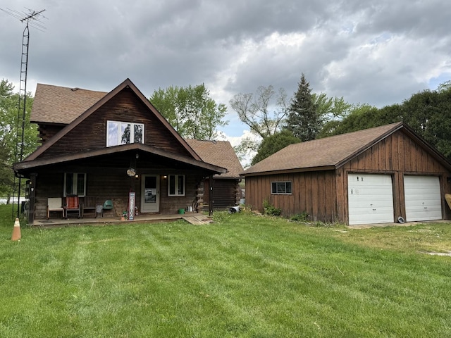1170 Towpath Ln, Wilmington, IL 60481 - view of front of property featuring a detached garage, a front lawn, covered porch, a shingled roof, and an outbuilding