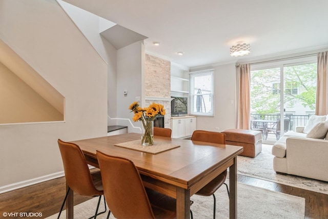 1835 W Oakdale Ave Unit E, Chicago, IL 60657 - dining area with wood finished floors, crown molding, baseboards, built in shelves, and a stone fireplace