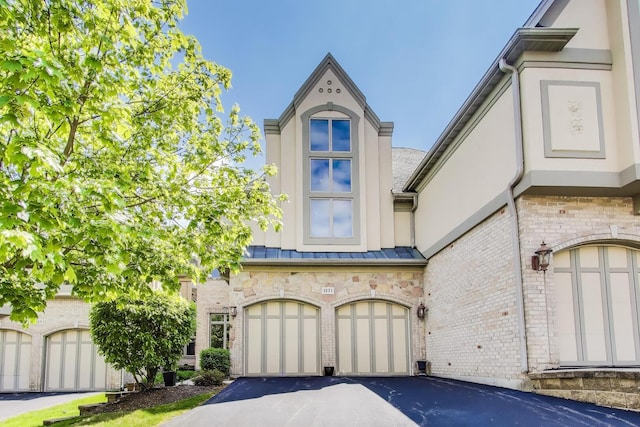 1571 W Rue James Pl, Palatine, IL 60067 - view of property featuring a standing seam roof, driveway, stucco siding, and an attached garage