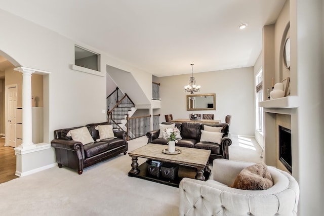 1571 W Rue James Pl, Palatine, IL 60067 - living room featuring arched walkways, decorative columns, a fireplace, stairs, and a chandelier