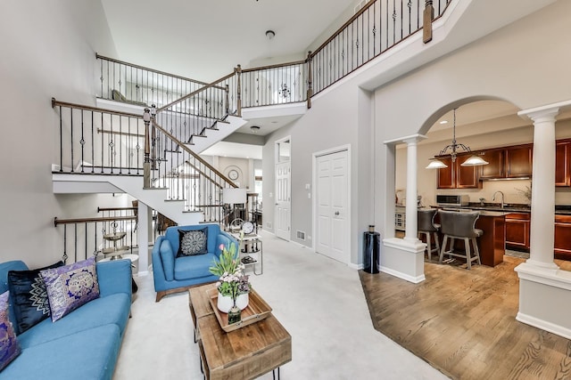 1571 W Rue James Pl, Palatine, IL 60067 - living area with ornate columns, a towering ceiling, stairs, arched walkways, and baseboards