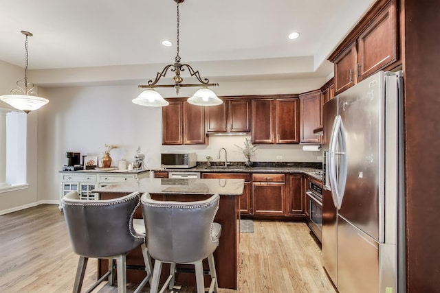 1571 W Rue James Pl, Palatine, IL 60067 - kitchen featuring stainless steel appliances, a sink, light wood-type flooring, a breakfast bar area, and a kitchen island