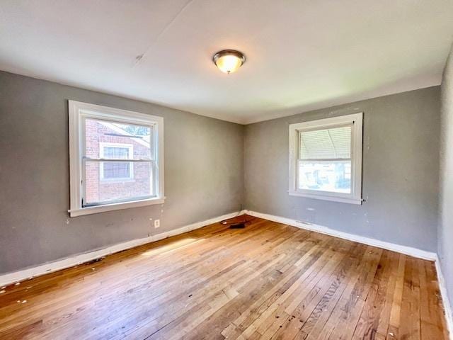 spare room with plenty of natural light, hardwood / wood-style floors, and baseboards