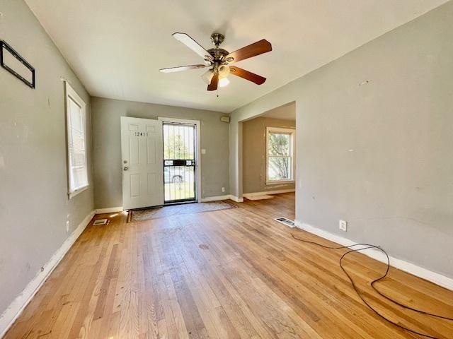 unfurnished room with baseboards, light wood-type flooring, and a ceiling fan