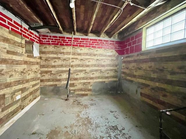basement featuring wood walls