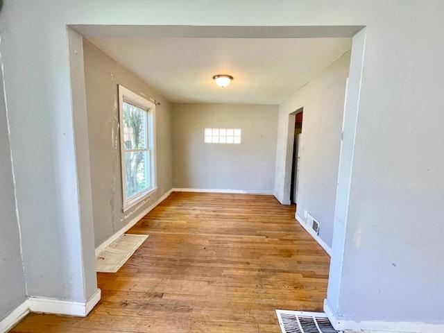 empty room with hardwood / wood-style flooring and baseboards