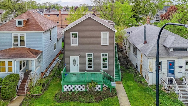 rear view of house featuring stairway, a deck, a yard, and a residential view