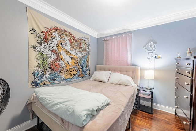 bedroom with baseboards, crown molding, and wood finished floors