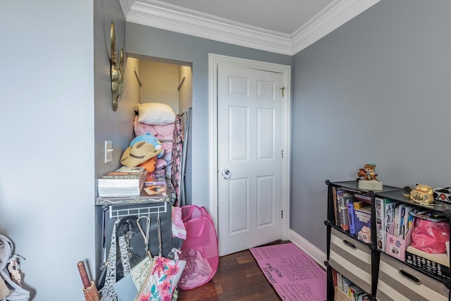 foyer featuring crown molding, wood finished floors, and baseboards