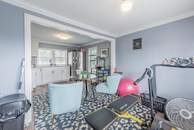 living area featuring ornamental molding and wood finished floors