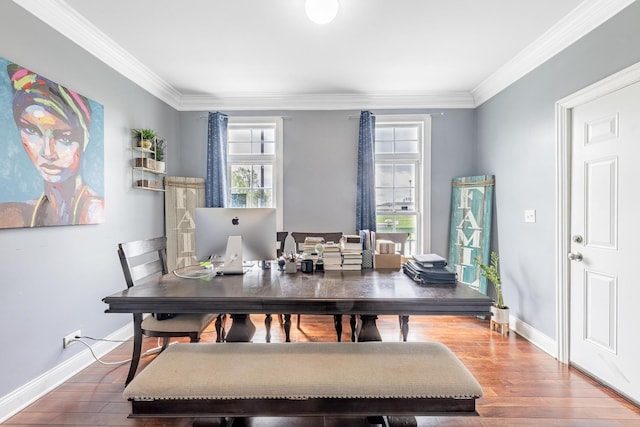 dining space with ornamental molding, wood finished floors, and baseboards