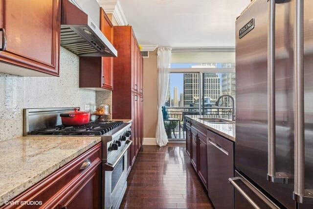 1400 S Michigan Ave Unit 2303, Chicago, IL 60605 - kitchen featuring appliances with stainless steel finishes, wall chimney exhaust hood, a sink, dark wood-style floors, and light stone countertops
