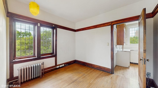 1366 E 57th St Unit 3, Chicago, IL 60637 - empty room featuring radiator, light wood-style floors, and baseboards