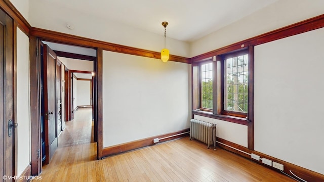 1366 E 57th St Unit 3, Chicago, IL 60637 - empty room with radiator, light wood finished floors, and baseboards