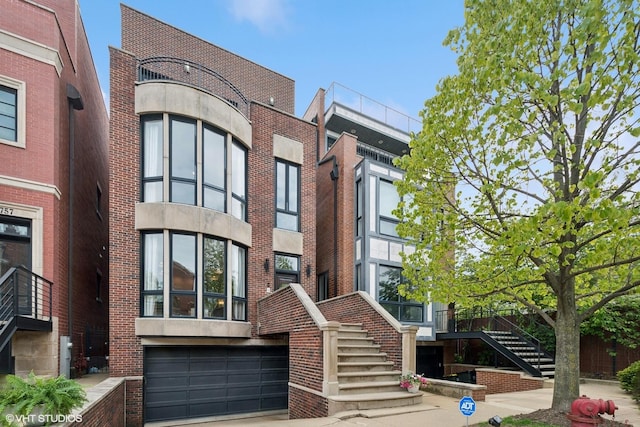 1759 W Surf St, Chicago, IL 60657 - view of property with stairs, a garage, and driveway