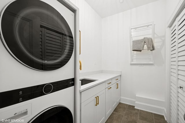 1759 W Surf St, Chicago, IL 60657 - laundry room with stacked washing machine and dryer, cabinet space, and baseboards