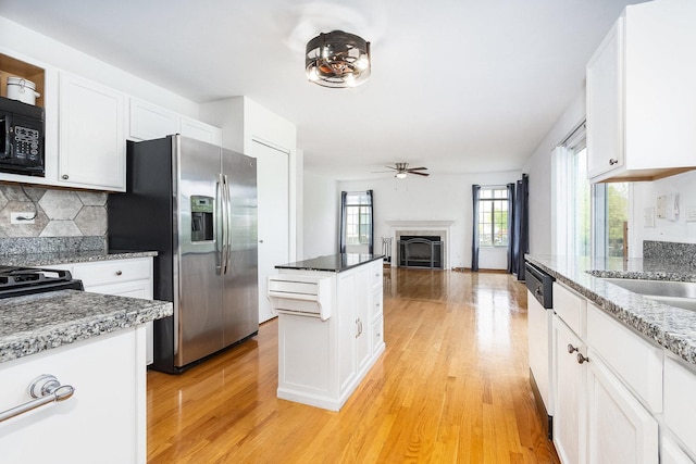 1376 Dahlgren Ln, Minooka, IL 60447 - kitchen featuring stainless steel fridge, black microwave, a fireplace, and light wood-style floors