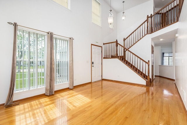 1376 Dahlgren Ln, Minooka, IL 60447 - entryway featuring wood finished floors, a towering ceiling, stairway, and baseboards