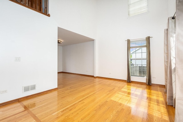 1376 Dahlgren Ln, Minooka, IL 60447 - spare room featuring a towering ceiling, wood finished floors, and baseboards
