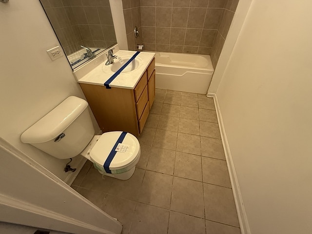 bathroom with tile patterned flooring, toilet, vanity, and baseboards