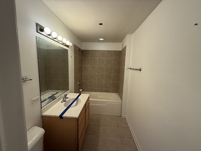 bathroom featuring tile patterned floors, toilet, vanity, shower / washtub combination, and baseboards