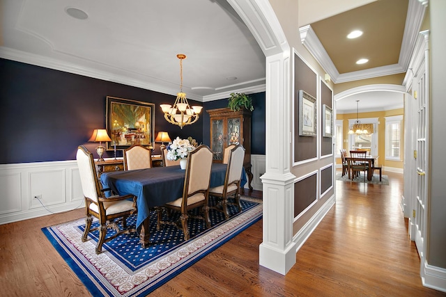 22388 Crimson Ln, Frankfort, IL 60423 - dining room featuring a chandelier, arched walkways, crown molding, decorative columns, and wood finished floors