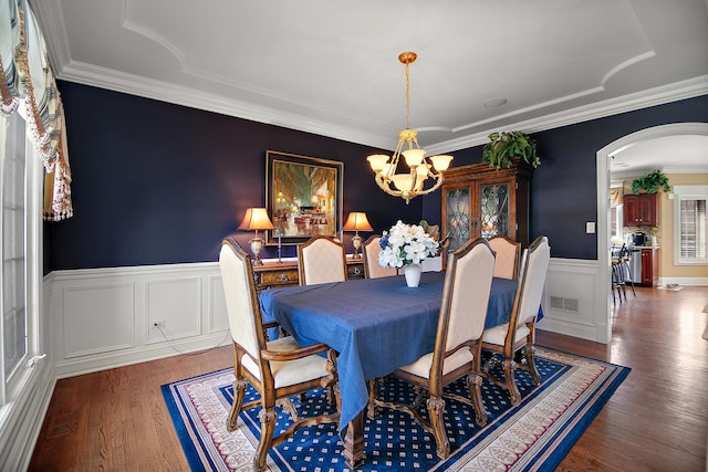 22388 Crimson Ln, Frankfort, IL 60423 - dining area featuring a chandelier, arched walkways, a wainscoted wall, wood finished floors, and crown molding