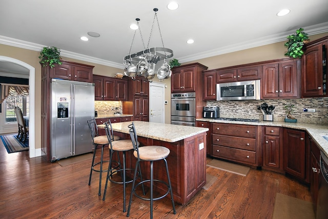 22388 Crimson Ln, Frankfort, IL 60423 - kitchen with stainless steel appliances, arched walkways, a center island, backsplash, and dark wood finished floors