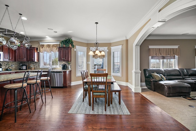 22388 Crimson Ln, Frankfort, IL 60423 - dining room featuring a chandelier, dark wood-style floors, arched walkways, ornamental molding, and baseboards