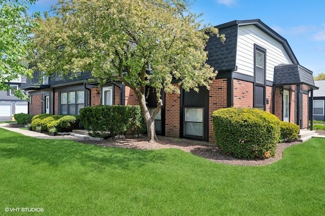view of front of house featuring brick siding, a front lawn, and a shingled roof