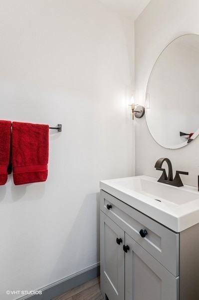bathroom with vanity, wood finished floors, and baseboards