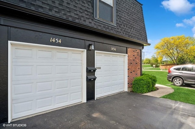 garage featuring asphalt driveway