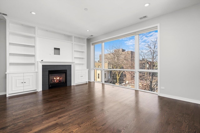 513 N Claremont Ave Unit 3S, Chicago, IL 60612 - unfurnished living room featuring baseboards, a lit fireplace, wood finished floors, recessed lighting, and built in features