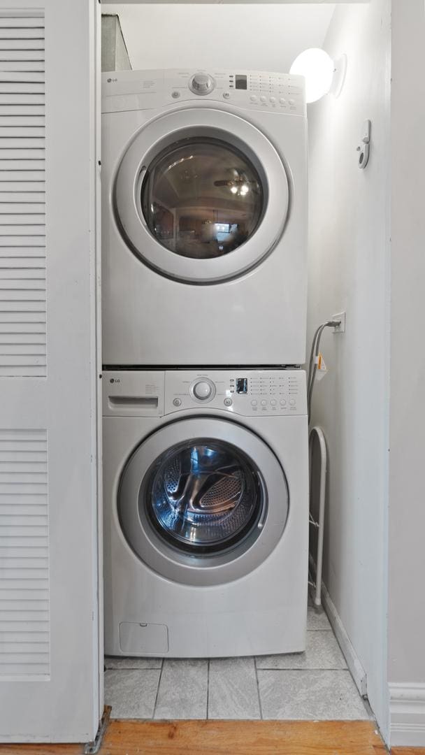 2544 W George St Unit 2, Chicago, IL 60618 - laundry area with stacked washing machine and dryer and light tile patterned floors