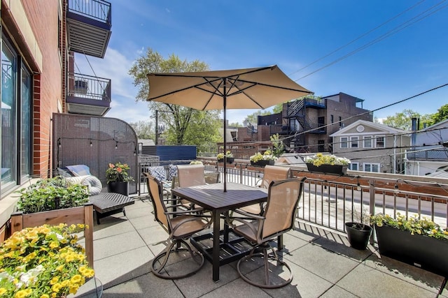 view of patio / terrace with a balcony and outdoor dining space