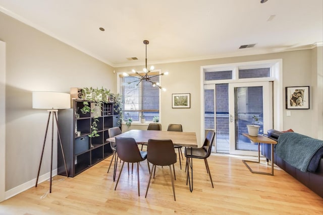 dining room featuring light wood-style floors, a chandelier, ornamental molding, and baseboards