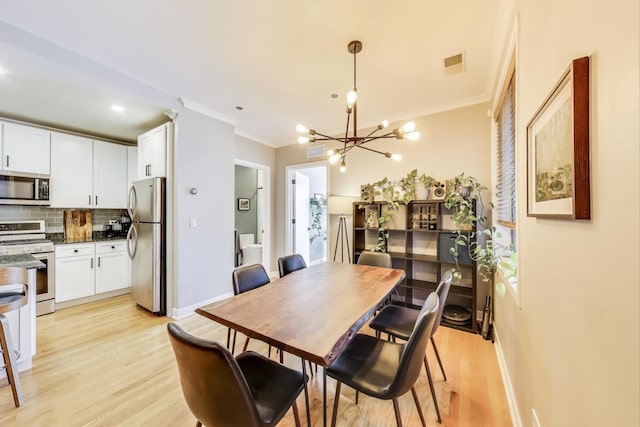 2700 N Halsted St Unit 211, Chicago, IL 60614 - dining space featuring a chandelier, ornamental molding, baseboards, and light wood-style floors
