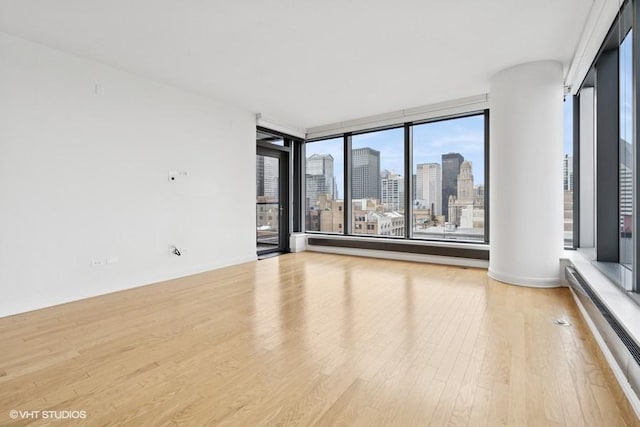 60 E Monroe St Unit 2607, Chicago, IL 60603 - spare room with wood finished floors, a view of skyline, plenty of natural light, and baseboard heating