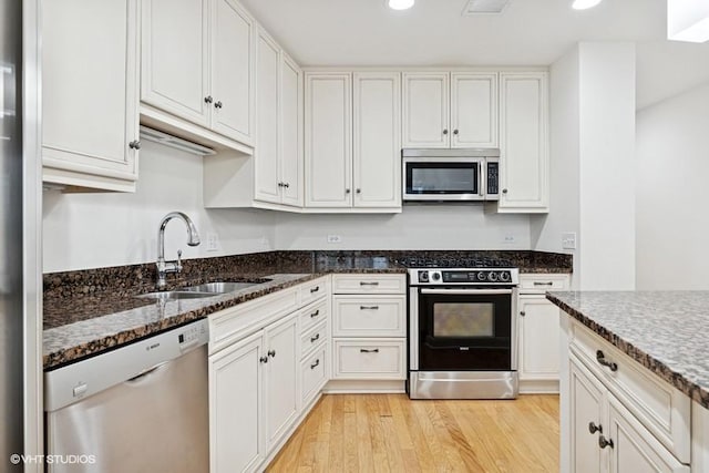 60 E Monroe St Unit 2607, Chicago, IL 60603 - kitchen featuring appliances with stainless steel finishes, a sink, light wood-style flooring, dark stone countertops, and recessed lighting