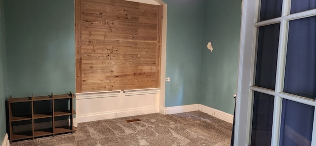 carpeted spare room featuring baseboards