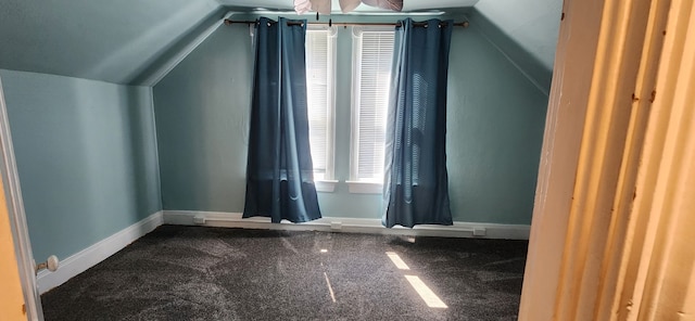 additional living space featuring vaulted ceiling, carpet flooring, baseboards, and ceiling fan