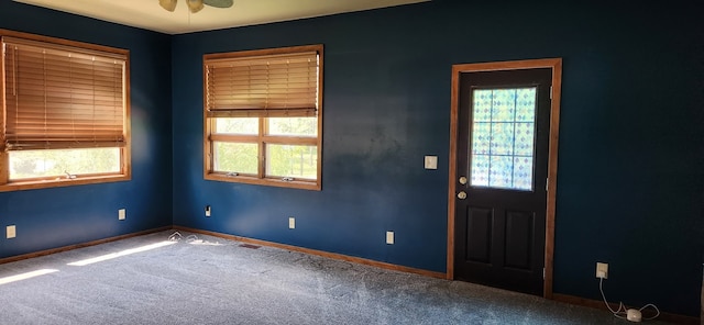 foyer featuring carpet flooring, baseboards, and a ceiling fan