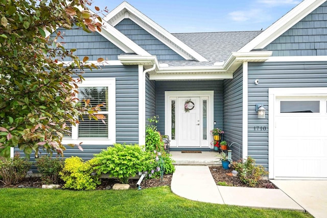 doorway to property featuring a garage and roof with shingles