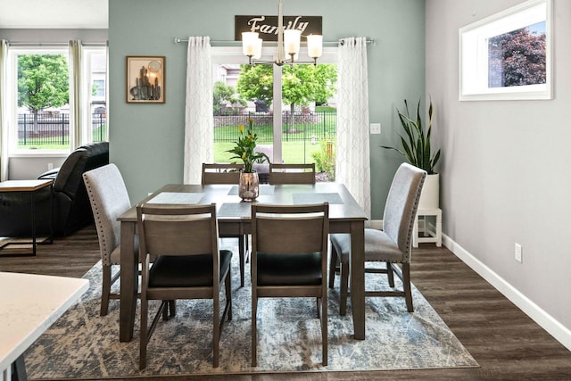 dining area with a chandelier, dark wood-type flooring, and baseboards