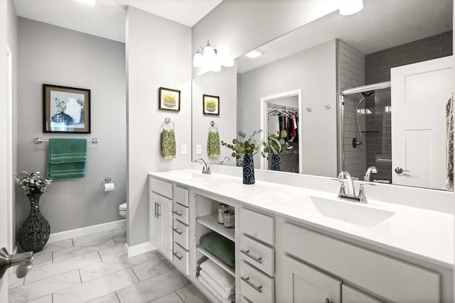 full bath featuring a shower stall, marble finish floors, toilet, double vanity, and a spacious closet
