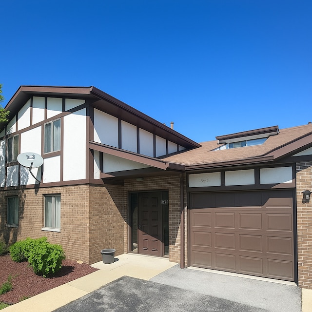 5024 W 122nd St Unit 2B, Alsip, IL 60803 - view of front of property featuring brick siding, asphalt driveway, an attached garage, and stucco siding