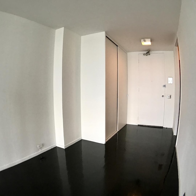 unfurnished room featuring baseboards and finished concrete floors